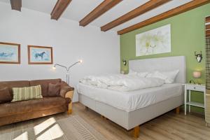 a bedroom with a bed and a couch at Ferienhof Radlandsichten in Malente