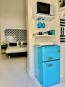a blue refrigerator in a living room with a couch at MARILISE - La maison blue private garden & terrace in Meta