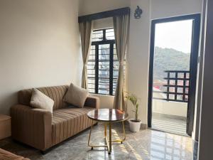 a living room with a couch and a table at The Notting Hills Inn in Shillong