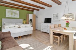 a living room with a bed and a table at Ferienhof Radlandsichten in Malente