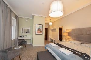 a bedroom with two beds and a desk and a chair at CIENISTA 7 APARTMENTS in Lądek-Zdrój