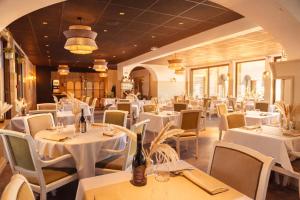 a dining room with white tables and chairs at Les Treize Assiettes - Baie du Mont-Saint-Michel in Le Val-Saint-Père