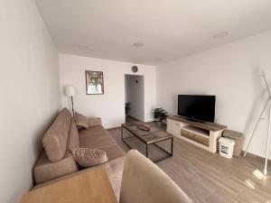 a living room with a couch and a flat screen tv at Best4You Apartment Therme Airport in Baloteşti