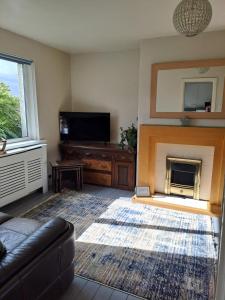 a living room with a couch and a fireplace at Hazel's House in Keighley