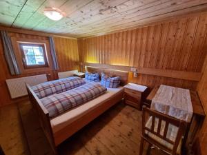 a bedroom with a bed and a wooden wall at Ferienhaus im Bergidyll in Sankt Jakob in Defereggen