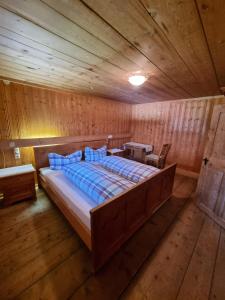 a bedroom with a large bed in a wooden room at Ferienhaus im Bergidyll in Sankt Jakob in Defereggen +11 photos