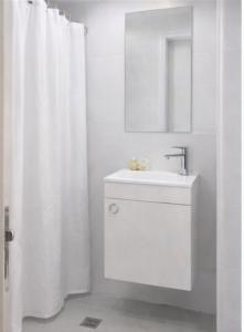 a white bathroom with a sink and a mirror at R suite delux in Netanya