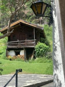 an old wooden house in the grass next to a street at Ferienhaus im Bergidyll in Sankt Jakob in Defereggen