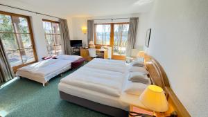 a hotel room with two beds and a desk at Hotel und Gutsgaststätte Rappenhof in Weinsberg