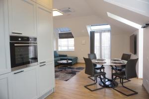 a kitchen and living room with a table and chairs at Modern New-Build Apt, managed by RentiFor in Klaipėda