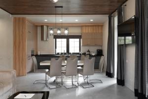 a dining room and kitchen with a table and chairs at Greitser Elit Chalet in Bukovel