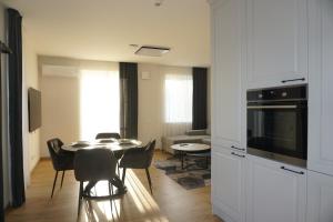 a kitchen and dining room with a table and chairs at Modern New-Build Apt, managed by RentiFor in Klaipėda +21 photos