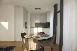 a kitchen with a table and chairs in a room at Modern New-Build Apt, managed by RentiFor in Klaipėda