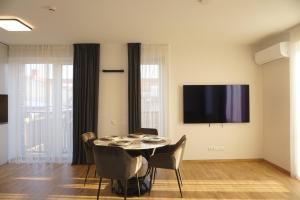 a dining room with a table and a flat screen tv at Modern New-Build Apt, managed by RentiFor in Klaipėda