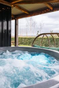 a jacuzzi tub with blue water in it at Square 32 Luxury Shipping container in Knockcloghrim