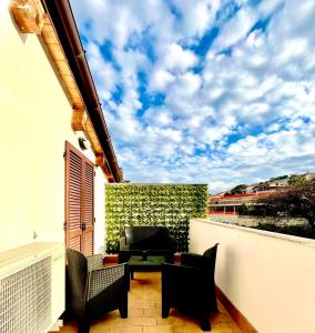 a balcony with black chairs and a white wall at Raggio di Sole in Montesilvano