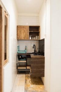 a kitchen with wooden cabinets and a sink at Kokomo Yogyakarta in Yogyakarta +32 photos