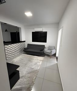 a living room with a couch and a tv at Quitinete inteligente Centro da Cidade Unidade 1 in Presidente Prudente