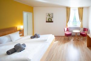 a hotel room with two beds and a table and chairs at Hotel zum Moselstrand in Briedern
