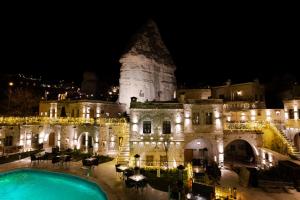 an old building with a swimming pool at night at Göreme Cave Suites in Göreme +211 photos