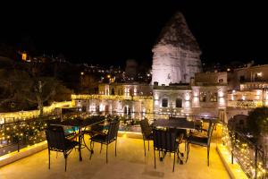 a view of a building with tables and chairs at night at Göreme Cave Suites in Göreme