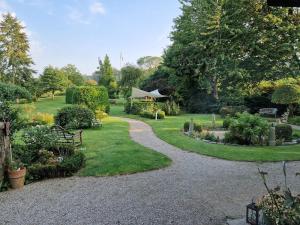 a garden with a gravel path and a gazebo at Ferienhof Radlandsichten in Malente