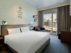 a hotel room with a large bed and a window at Rove Dubai Marina in Dubai