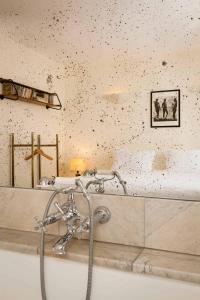a bath tub with a faucet in a bathroom at Hôtel Grand Amour in Paris +20 photos