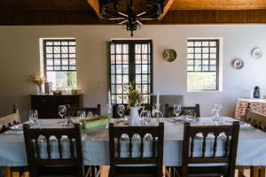 a dining room with a table and chairs and windows at Casa do Outeiro in Vila Meã