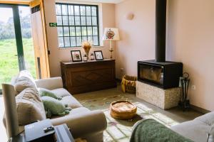 a living room with a couch and a fireplace at Casa do Outeiro in Vila Meã