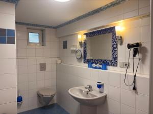 a bathroom with a sink and a toilet and a mirror at Hotel Rebstock in Rust +33 photos