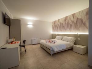 a bedroom with a bed and a desk and a television at Palombarone Resort in Matelica