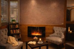 a living room with two chairs and a fireplace at Logis Hotel Le Lac in Embrun