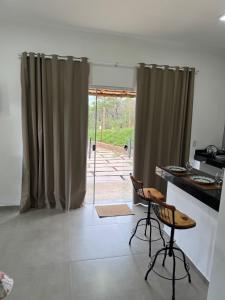 a kitchen with a table and two chairs in a room at Chalé portal da serra in Serra do Cipo