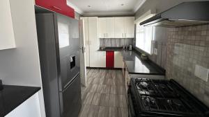 a kitchen with white cabinets and a stove top oven at Dessert Rose Guesthouse in Jwaneng