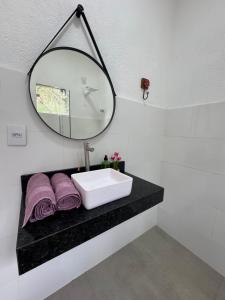 a bathroom with a sink and a mirror at Chalé portal da serra in Serra do Cipo +8 photos