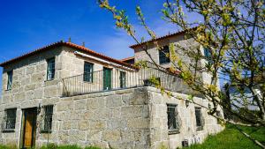 an old stone building with a red roof at Casa do Outeiro in Vila Meã