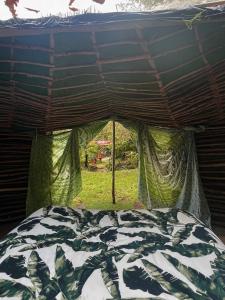a bed in a tent with a comforter at Selfmade Yurt - NaturViana in Viana do Castelo
