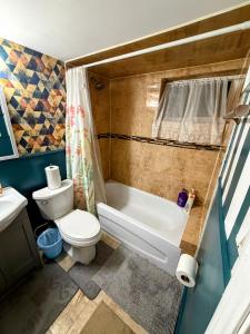 a bathroom with a toilet and a tub and a sink at Spacious room near subway & shops in Toronto +24 photos