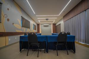 a conference room with a blue table and chairs at Hotel Opuka in Sorriso +78 photos