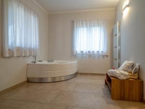a white bathroom with a tub and a window at Palombarone Resort in Matelica