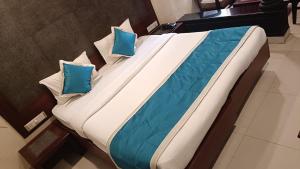 a large bed with two blue pillows on it at WoodLand Suites in Cochin
