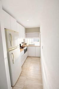 a kitchen with white cabinets and a white refrigerator at Brisas paraiso in Concepción del Uruguay