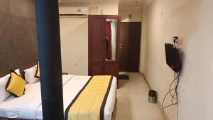a bedroom with a bed and a television in it at WoodLand Suites in Cochin