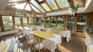 a dining room with tables and chairs and windows at Bickleigh Castle - A Majestic Devon Estate for Exclusive Gatherings in Winkleigh