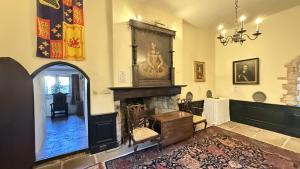 a living room with a fireplace and a chandelier at Bickleigh Castle - A Majestic Devon Estate for Exclusive Gatherings in Winkleigh