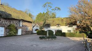 a large stone house with a grass roof at Bickleigh Castle - A Majestic Devon Estate for Exclusive Gatherings in Winkleigh