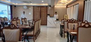 a dining room with tables and people in a restaurant at Devbhoomi Inn in Deoghar