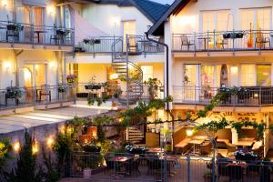 an apartment building with tables and chairs in the courtyard at Hotel zum Moselstrand in Briedern