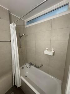 a bathroom with a bath tub and a window at Cosy studio in Lausanne Flon in Lausanne